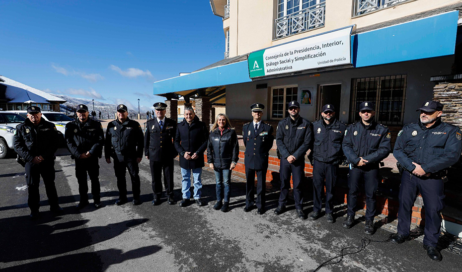 Los consejeros Antonio Sanz y Marifrán Carazo, junto a miembros de la Unidad de Policía Adscrita, en la fachada de las nuevas dependencias de Sierra Nevada.